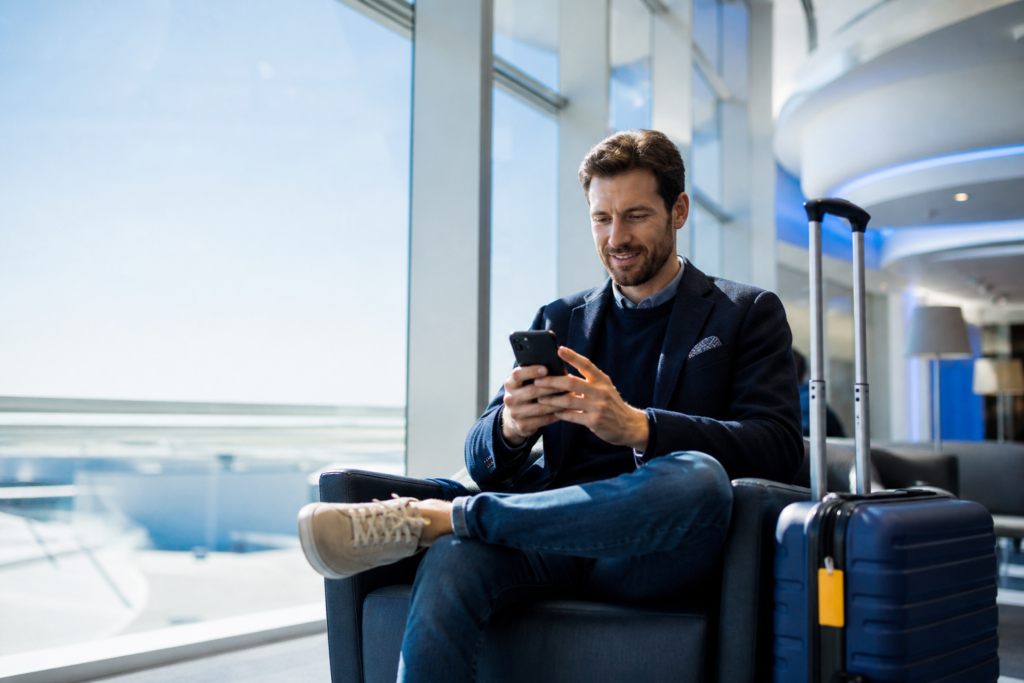 5G eSIM auf Reisen: Reisender nutzt schnelles mobiles Internet am Flughafen