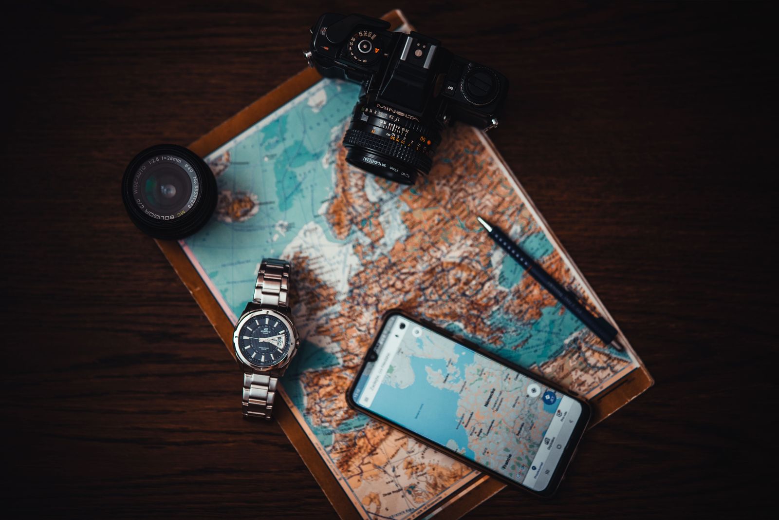 Carte, smartphone et accessoires de voyage pour planifier un séjour